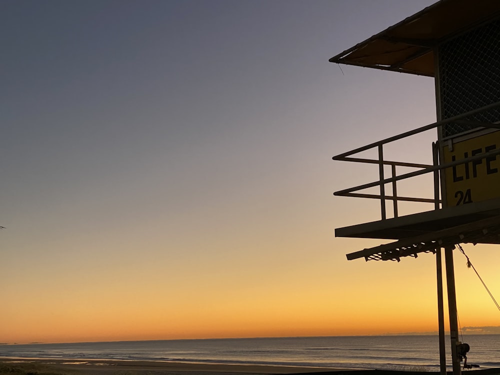 black and white lifeguard tower during sunset