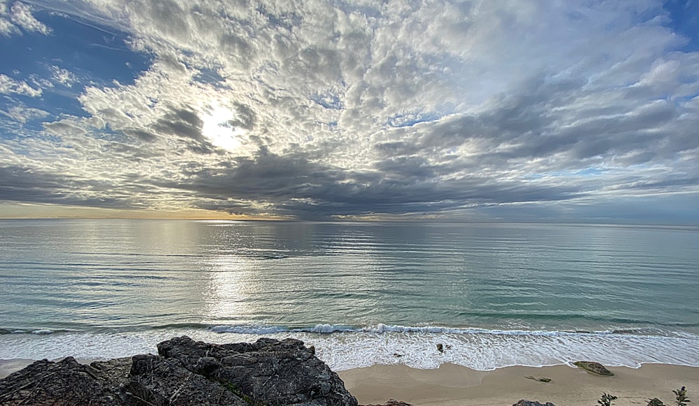 body of water under cloudy sky during daytime