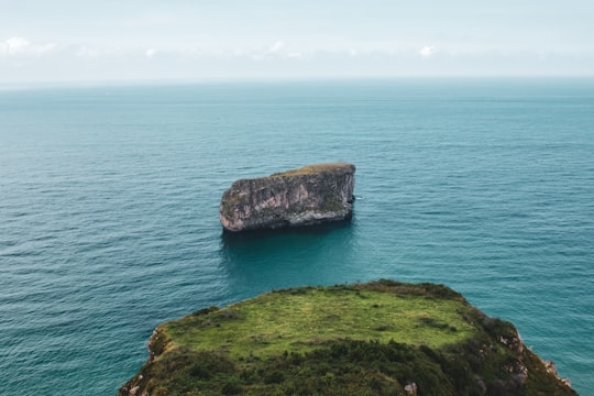 green and brown rock formation on sea during daytime in Asturias Spain