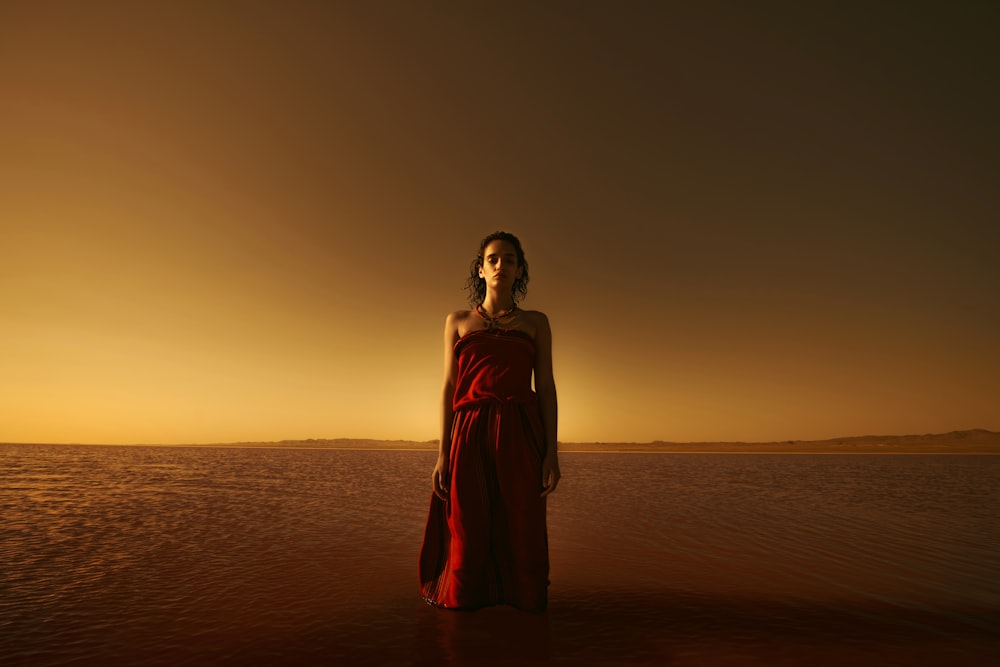 silhouette of woman standing on beach during sunset