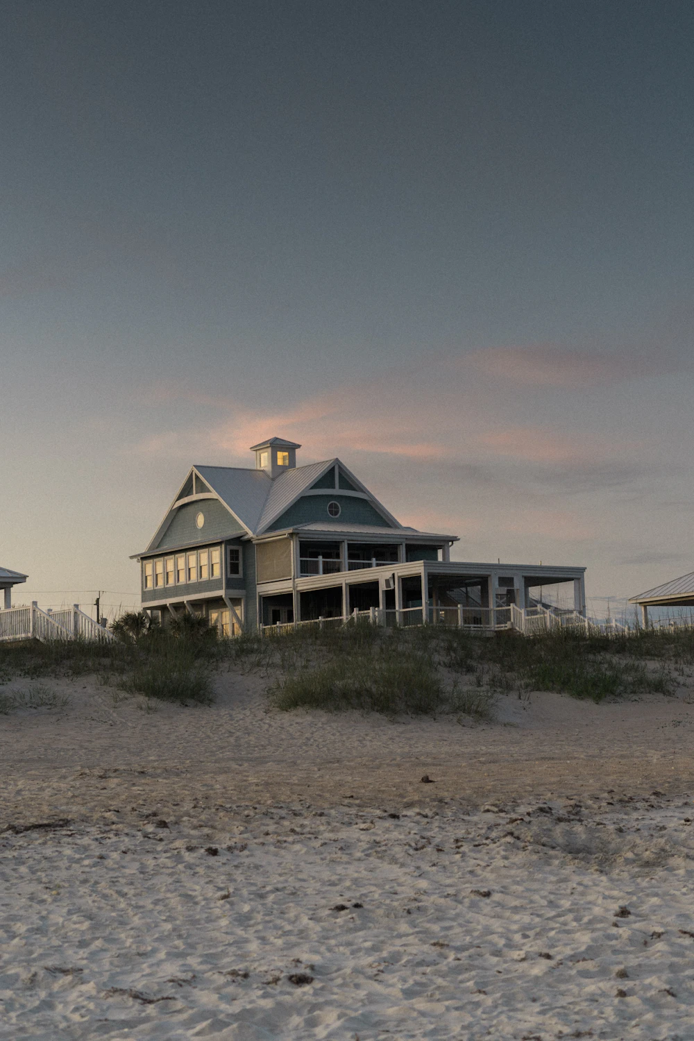 white and brown house near green grass field under gray sky