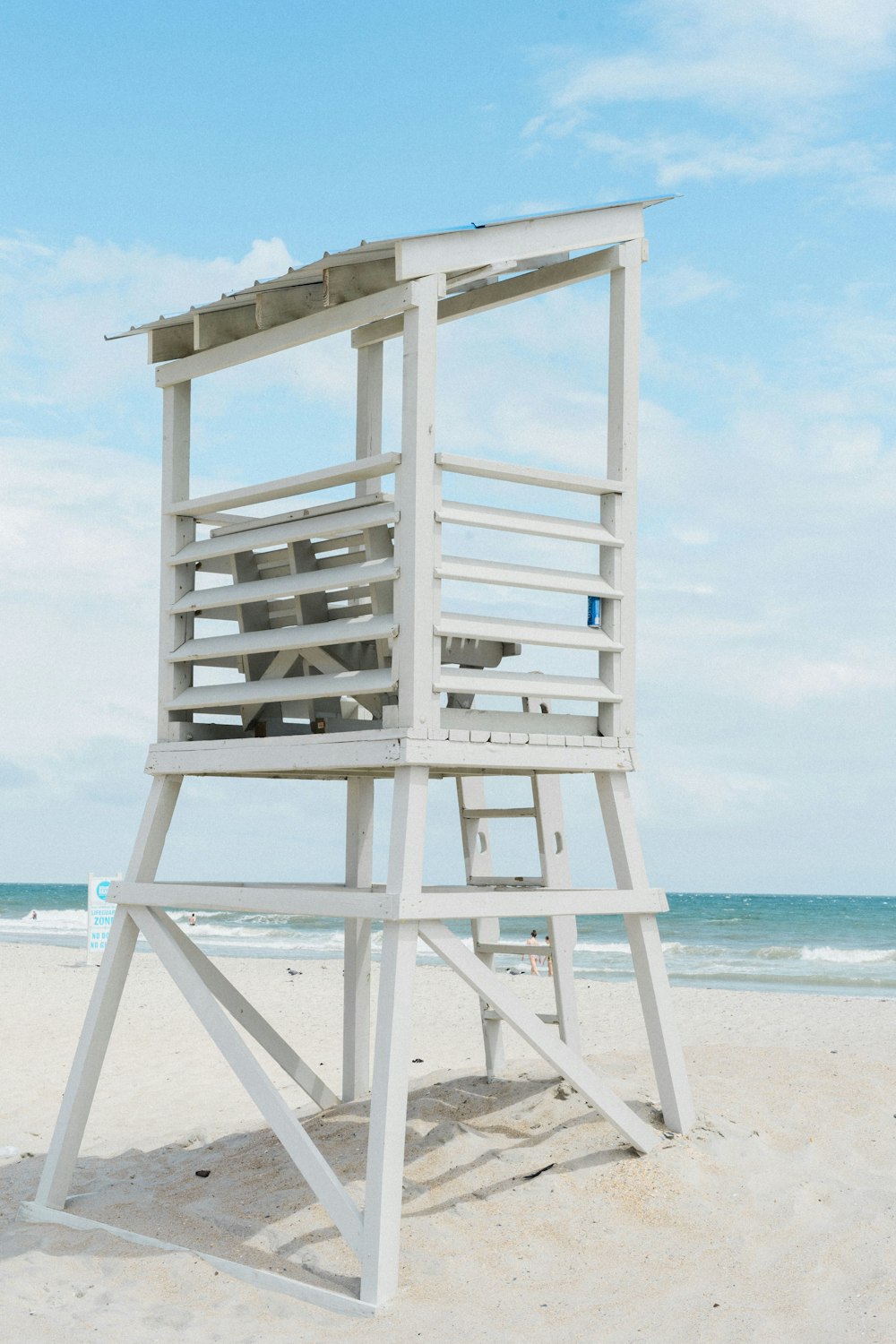 white wooden lifeguard tower on beach during daytime