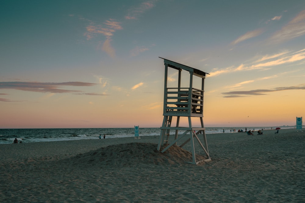 brown wooden lifeguard tower on beach shore during sunset