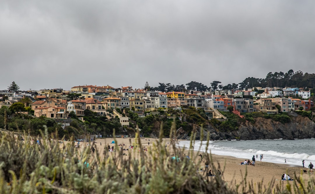 houses near sea under cloudy sky during daytime