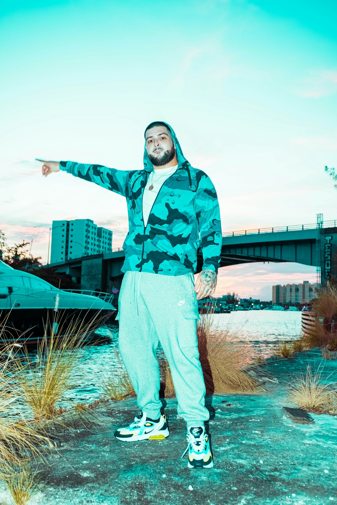 man in blue and black camouflage jacket standing on brown grass field during daytime