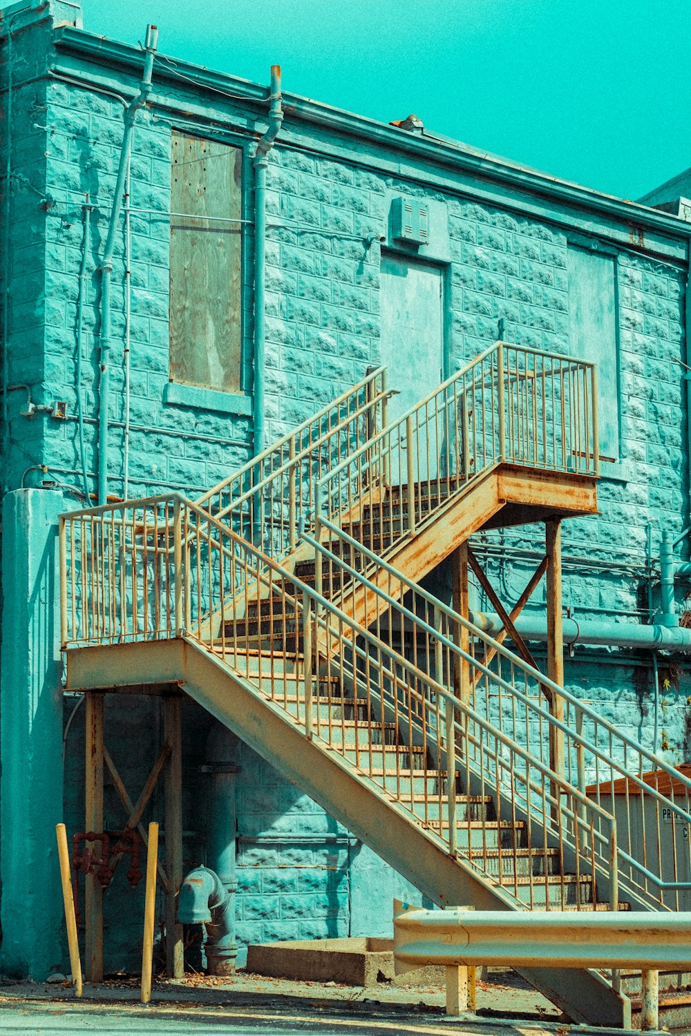 灰色のコンクリートの建物に茶色の木製の階段