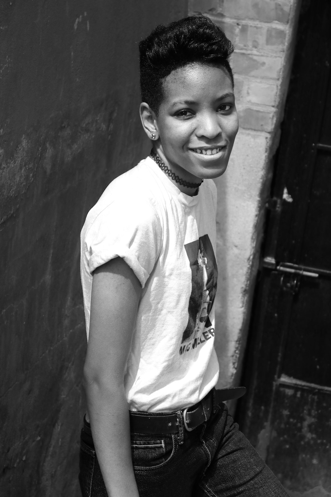 grayscale photo of smiling boy in crew neck t-shirt