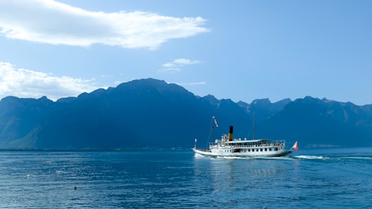 white ship on sea near mountain during daytime in Montreux Switzerland