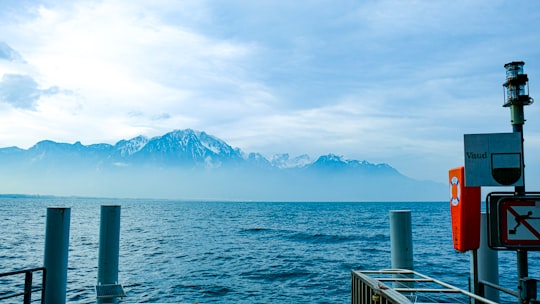 body of water near mountain under white sky during daytime in Montreux Switzerland