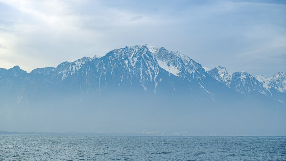 snow covered mountain near body of water during daytime