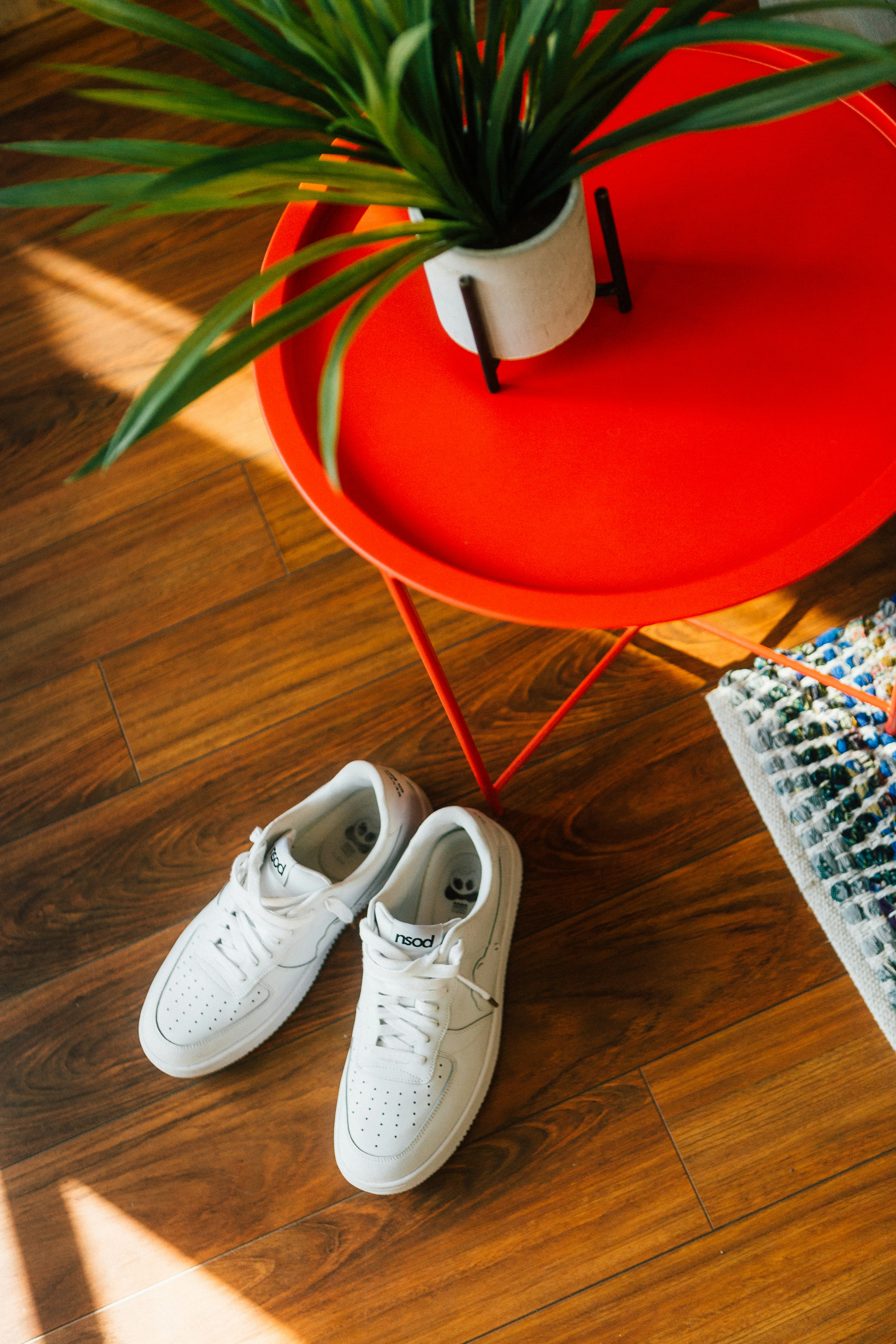 white and red nike sneakers on brown wooden floor