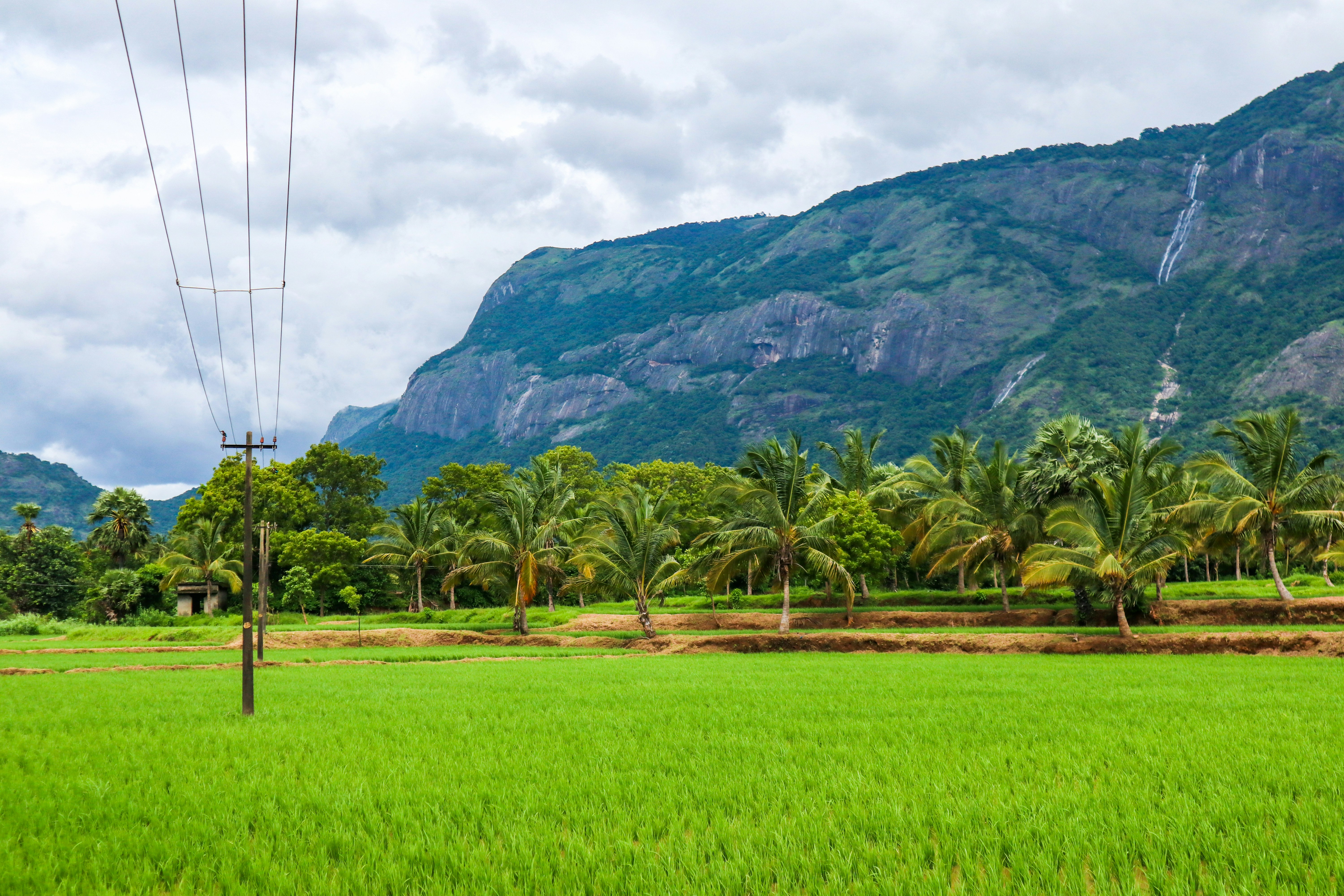 Green grass field near green mountain under white clouds during daytime ...