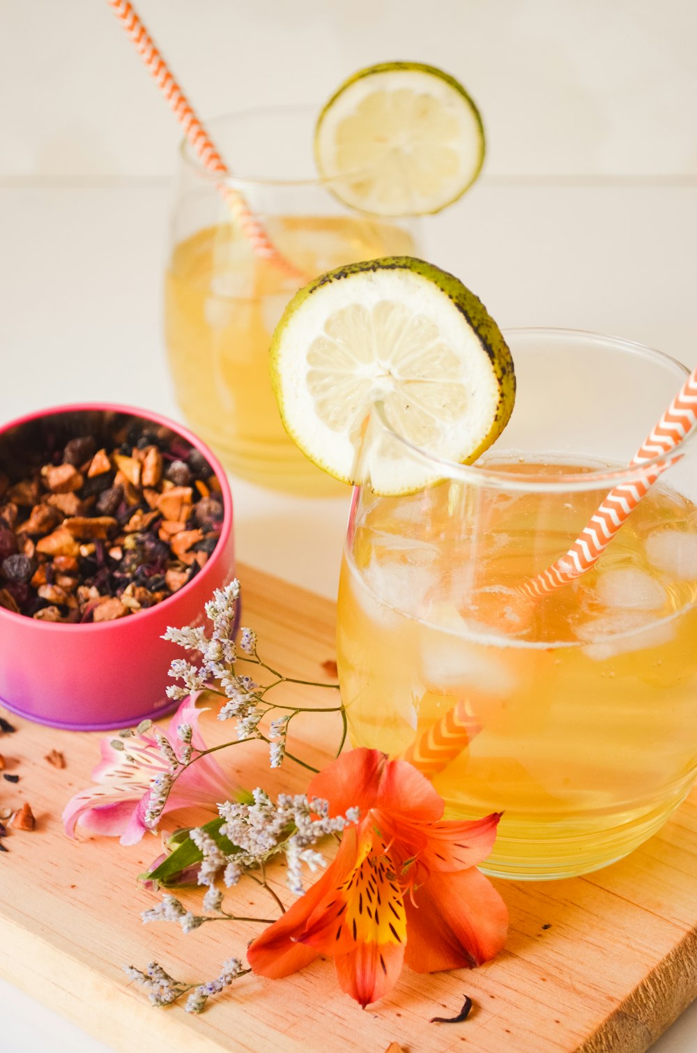 verre à boire transparent avec un liquide jaune et des tranches de citron