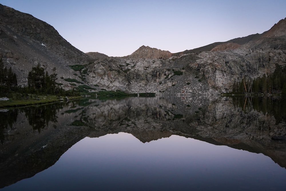 green and brown mountain beside body of water during daytime