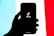 A silhouetted hand holds a smartphone displaying the TikTok logo on its screen, set against a tricolor background of light blue, white, and red.