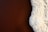 Aerial view of a contrast between a smooth, brown surface and a rough, white textured substance on the right. The white area appears to be crystalline or salt-like in texture.