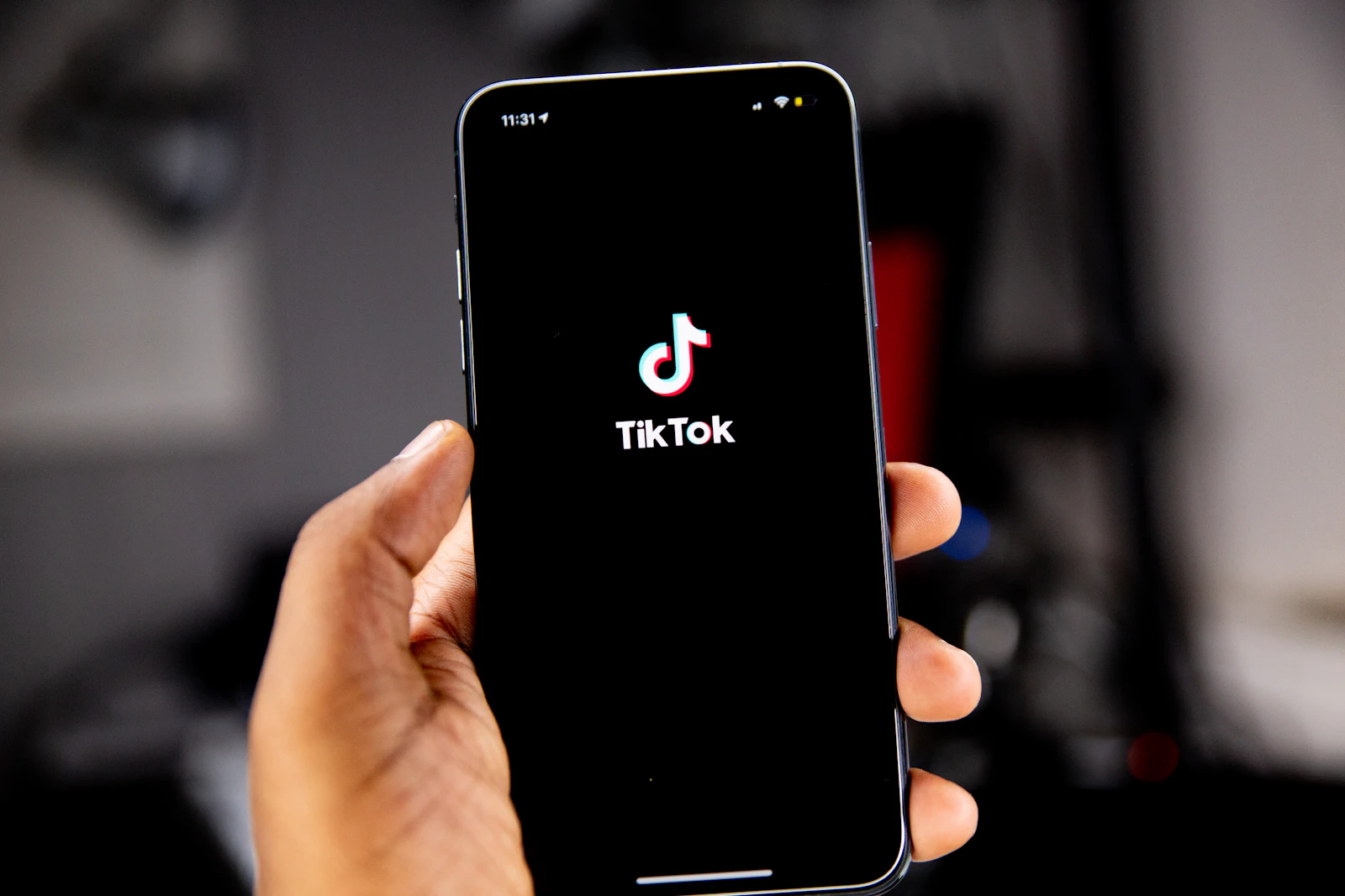 Mano sujetando un móvil con el logo de TikTok en pantalla