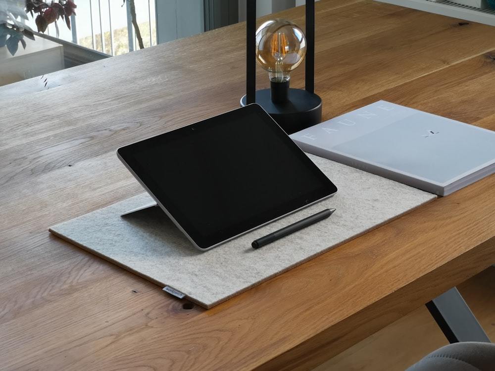black ipad on brown wooden table