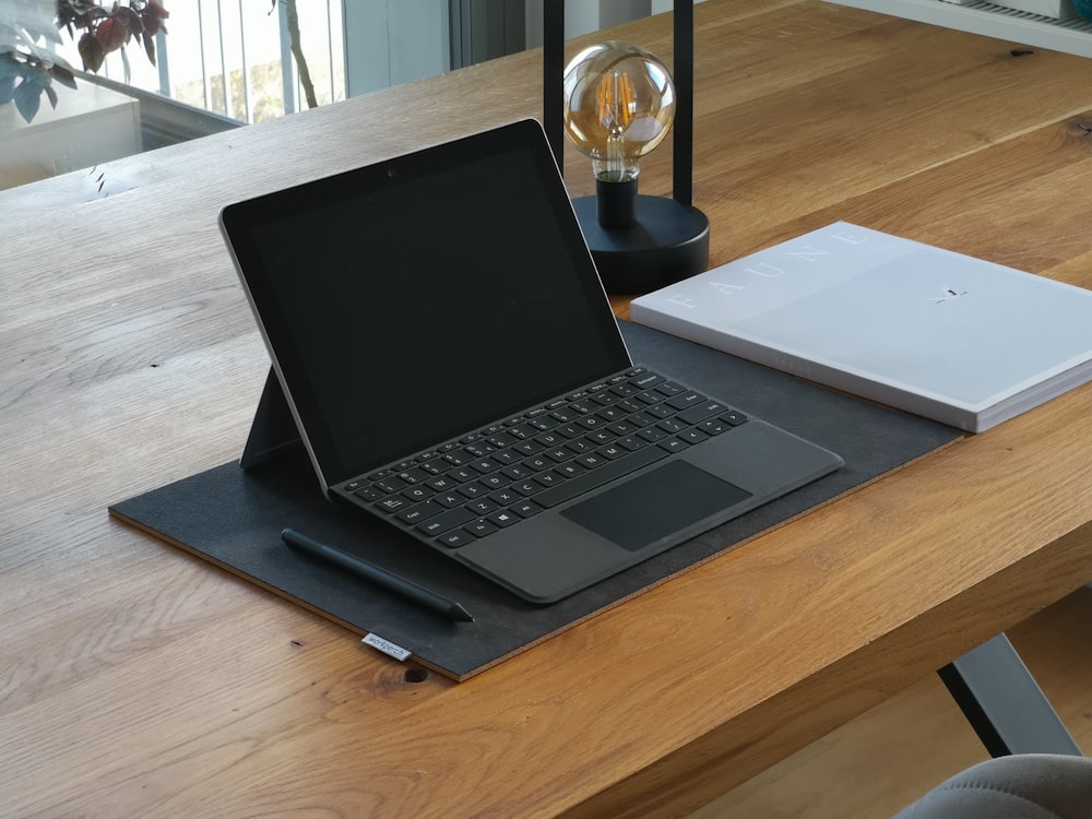 black and silver laptop computer on brown wooden table