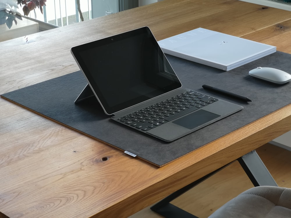 ordinateur portable noir et argent sur table en bois marron