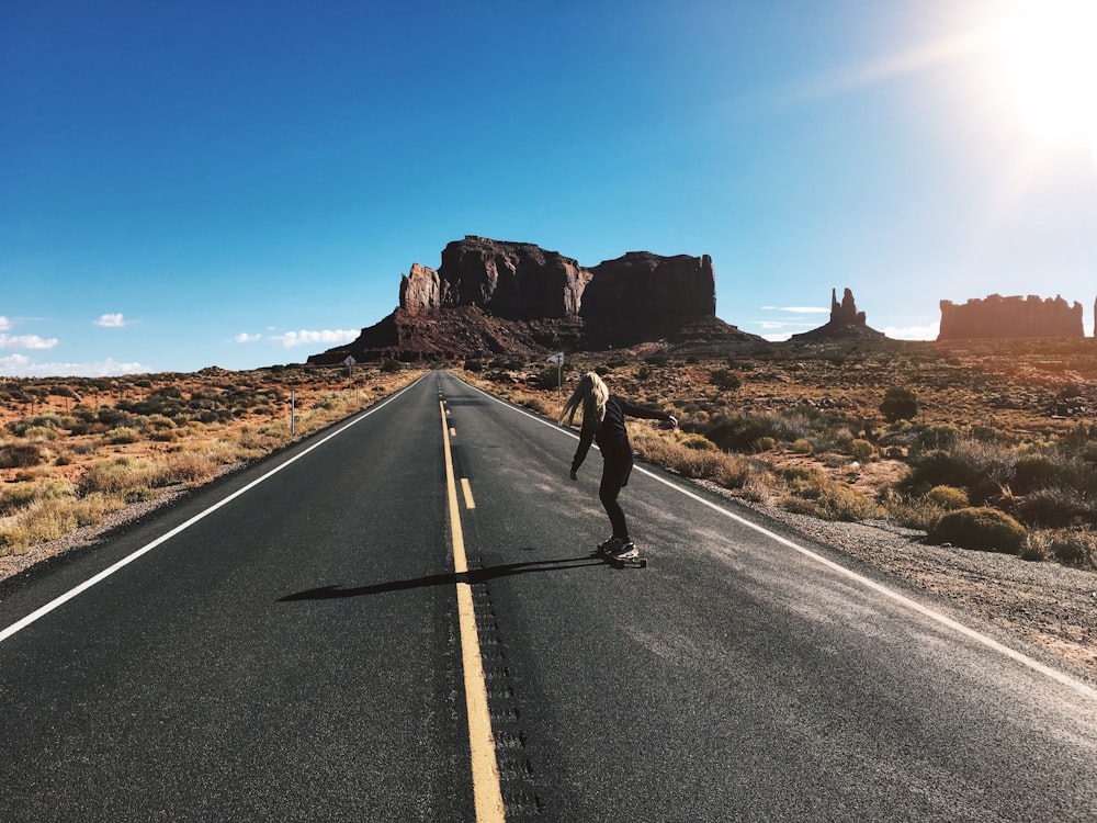 man in black jacket and black pants running on gray asphalt road during daytime