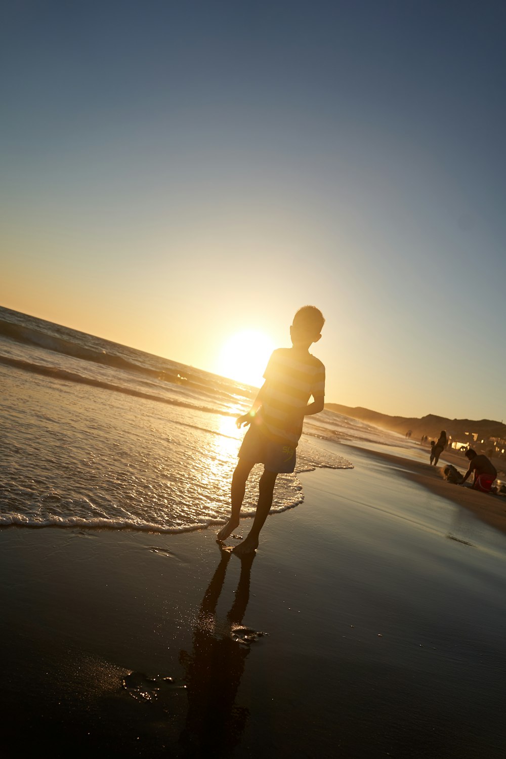 silhouette of man walking on beach during sunset