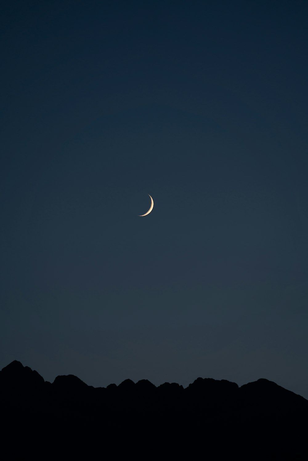 silhouette of mountain under crescent moon