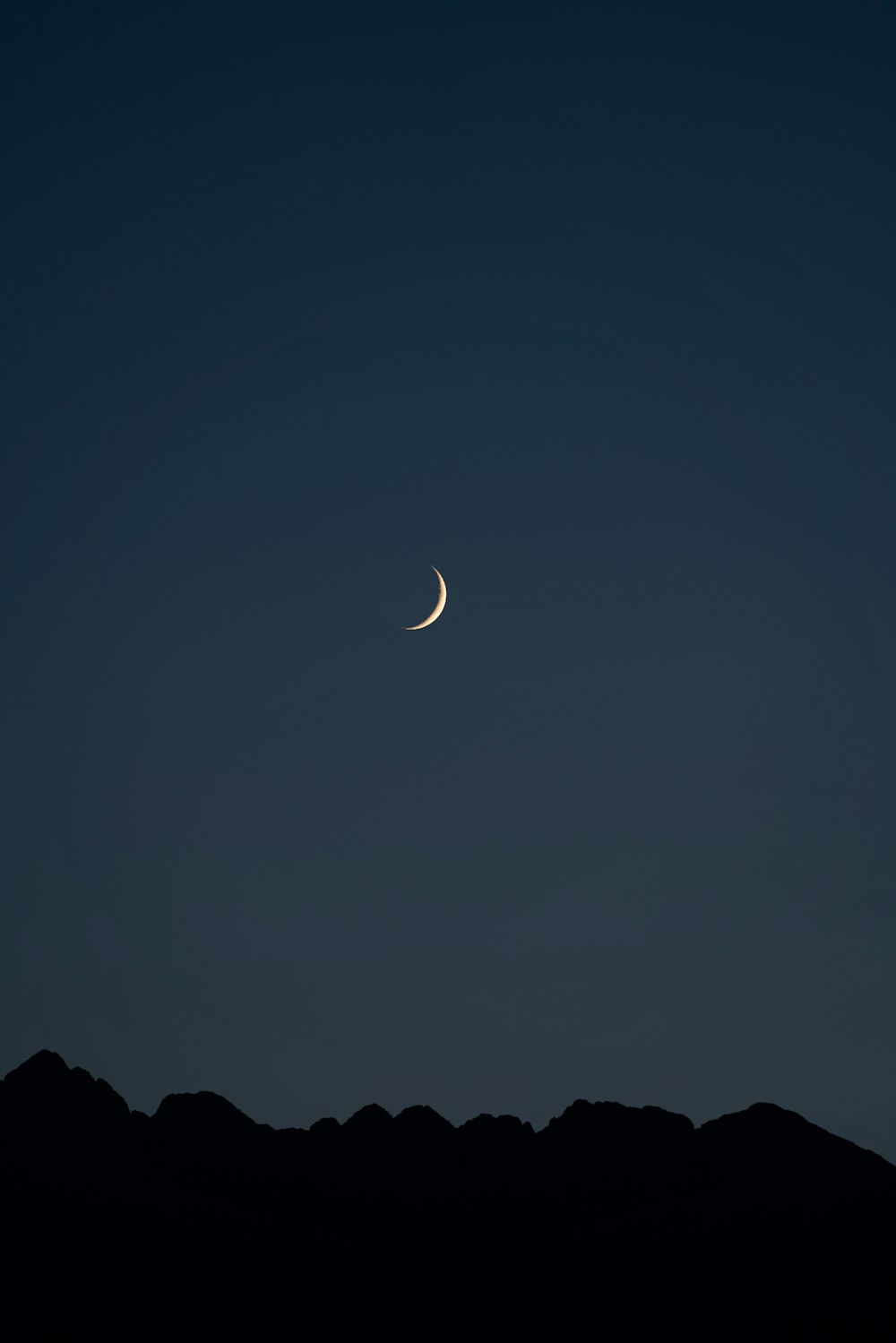 silhouette di montagna sotto la falce di luna