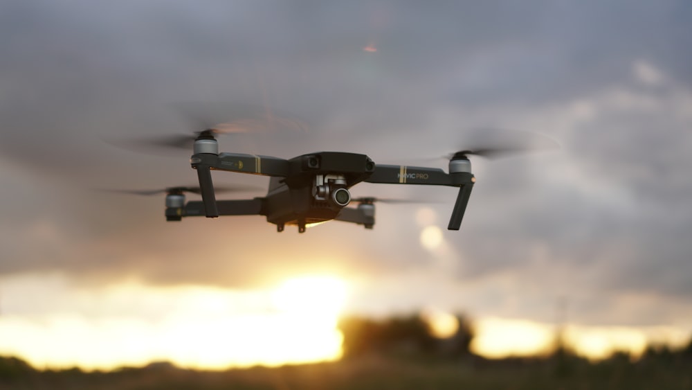 black drone flying in the sky during daytime