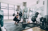 woman in black shirt and blue denim jeans sitting on black exercise equipment
