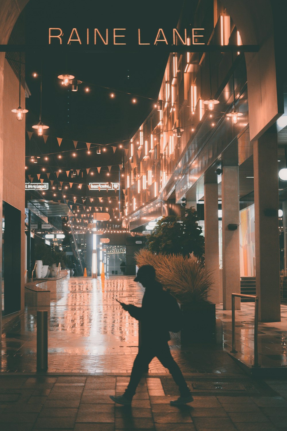 man in black jacket standing near building during night time