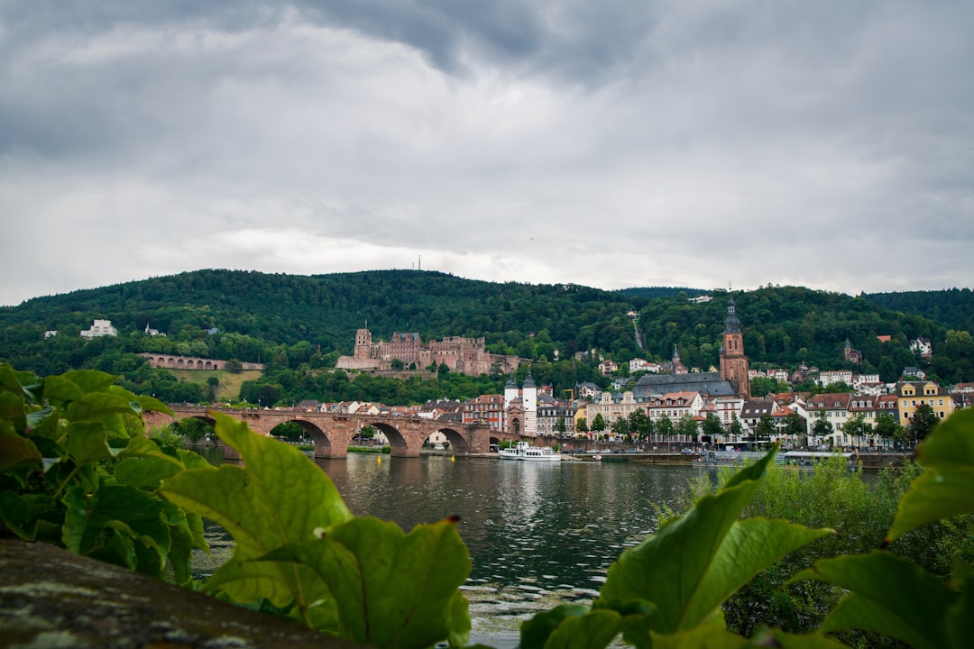 body of water near city buildings under cloudy sky during daytime