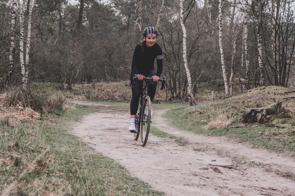 man in black jacket riding bicycle on dirt road during daytime