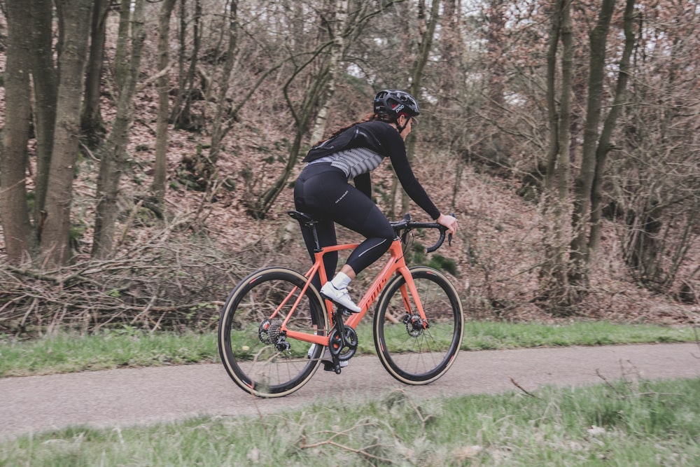 man in black jacket riding red bicycle