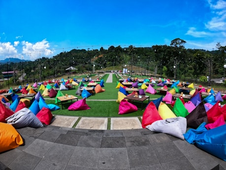 A vibrant cornhole board set up for a game of blackjack, featuring colorful bean bags and a sunny outdoor setting.
