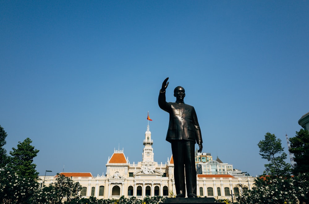 man statue near white building during daytime