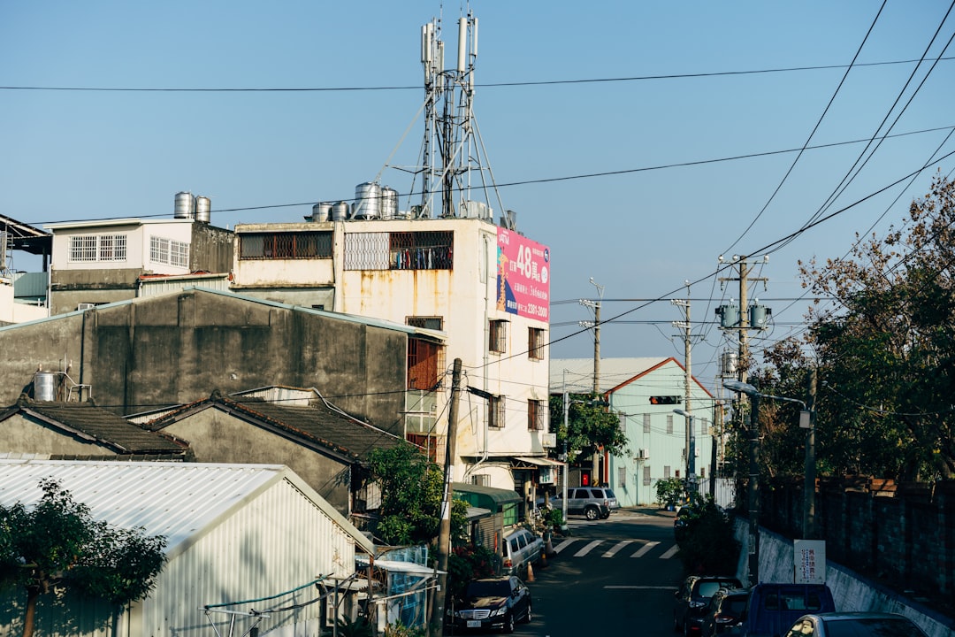 cars parked beside white building during daytime