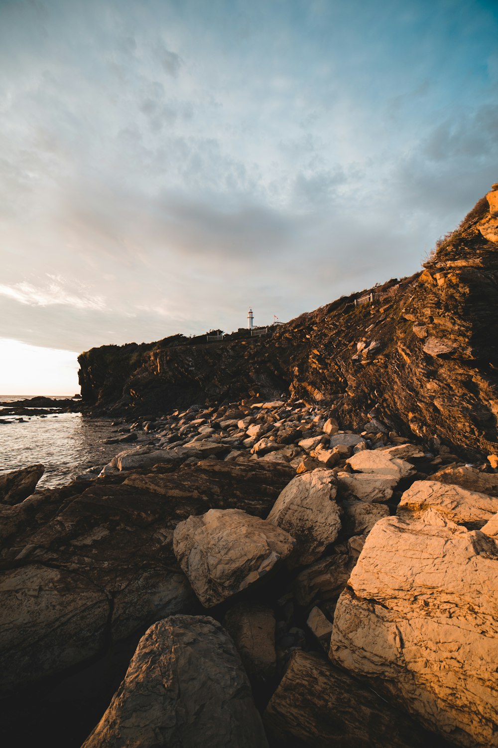 person standing on rock formation near body of water during daytime