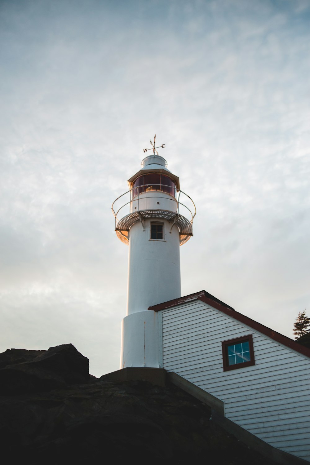 white and black lighthouse under white clouds during daytime