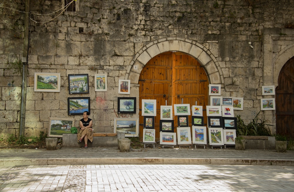 a woman sitting on a bench in front of a building