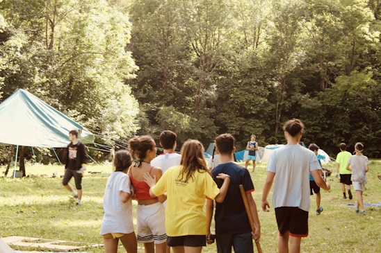 A group of diverse young people smiling and collaborating outdoors during a leadership workshop.