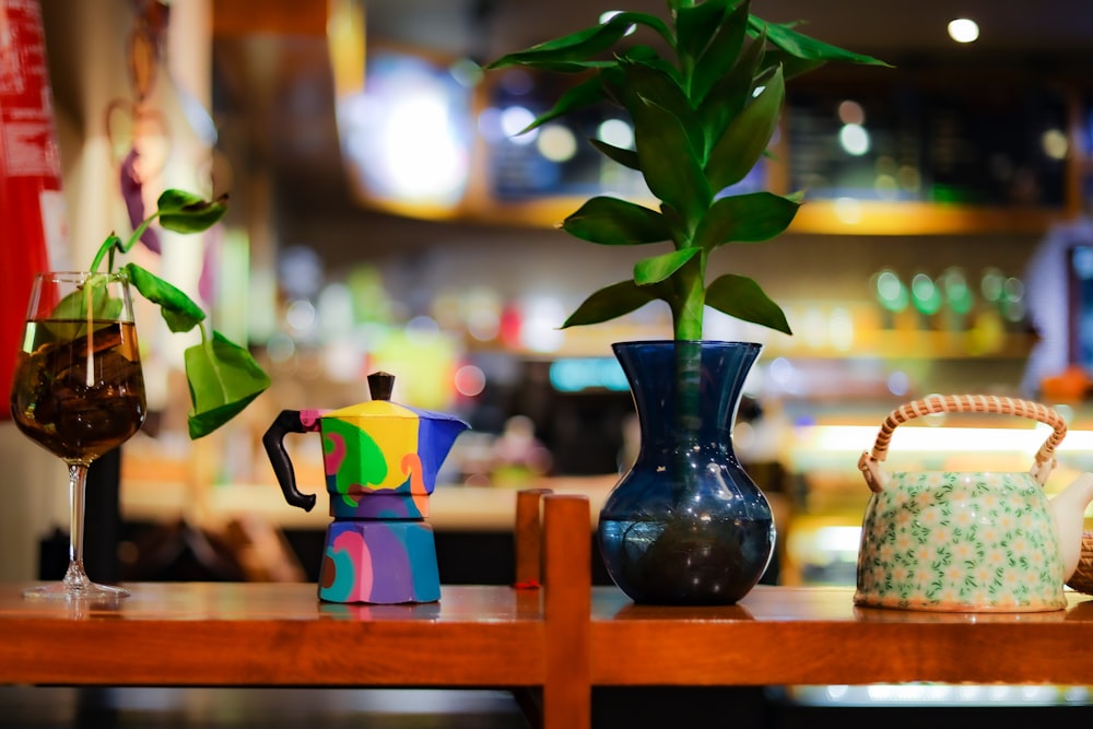 green plant in blue glass vase on brown wooden table