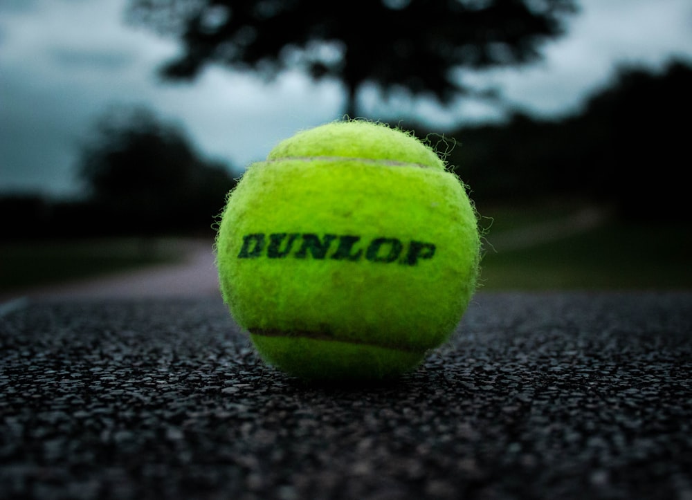 green tennis ball on black textile