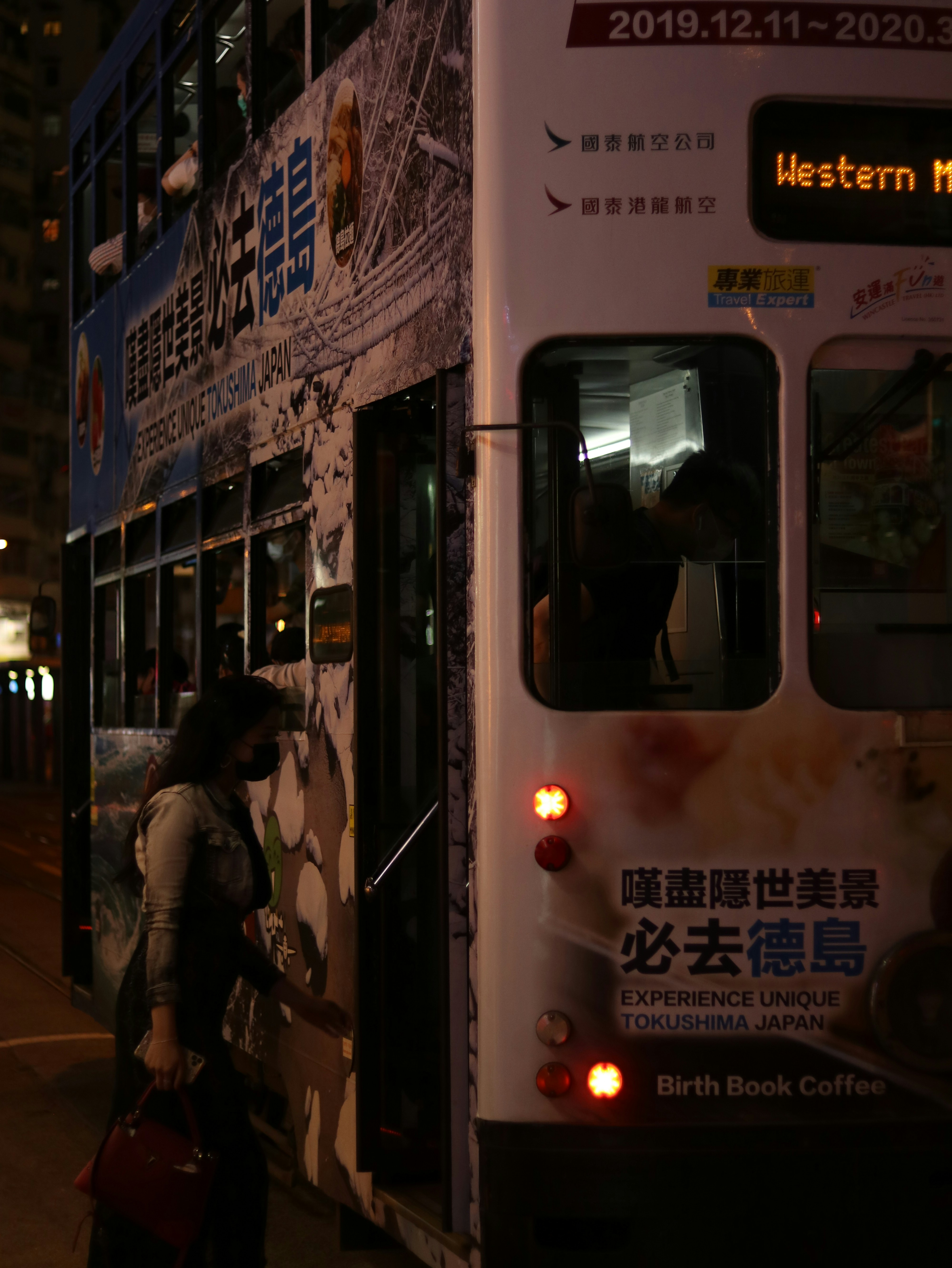 people walking on sidewalk near white bus during daytime