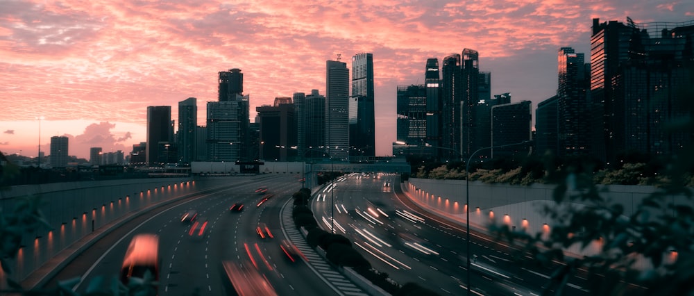 cars on road near city buildings during sunset