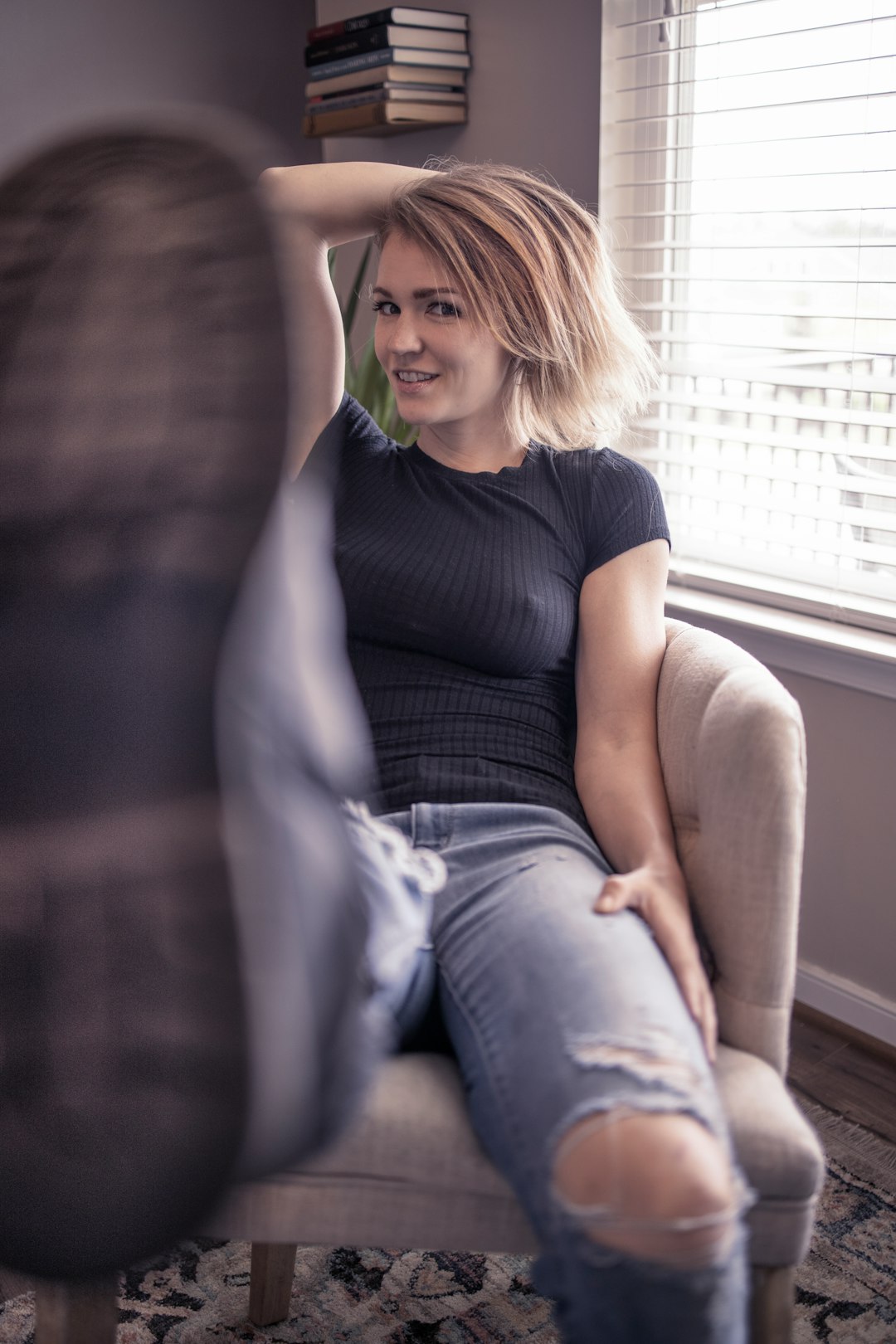 woman in black crew neck t-shirt and blue denim jeans sitting on white window