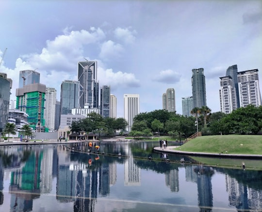 city skyline under cloudy sky during daytime in KLCC Park Malaysia