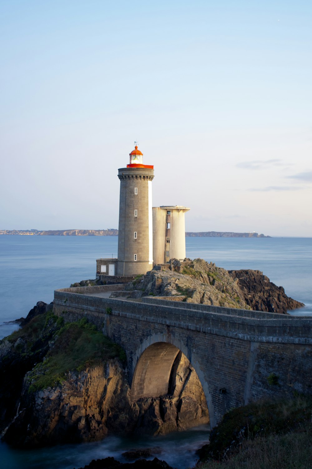 white lighthouse near body of water during daytime