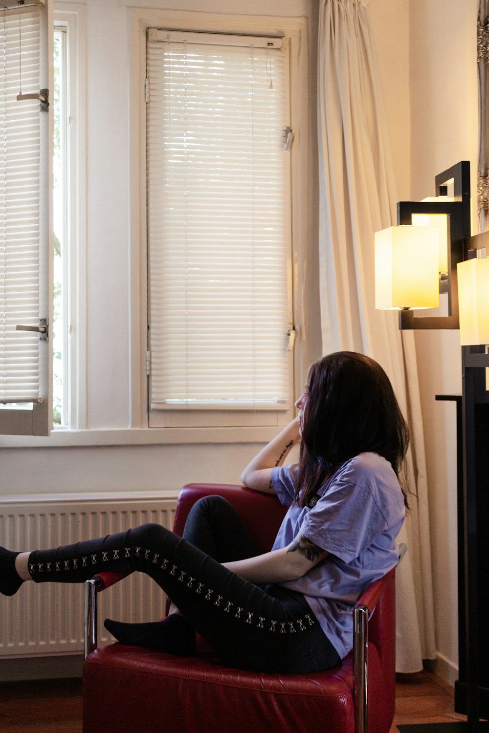 woman in blue shirt sitting on red sofa chair