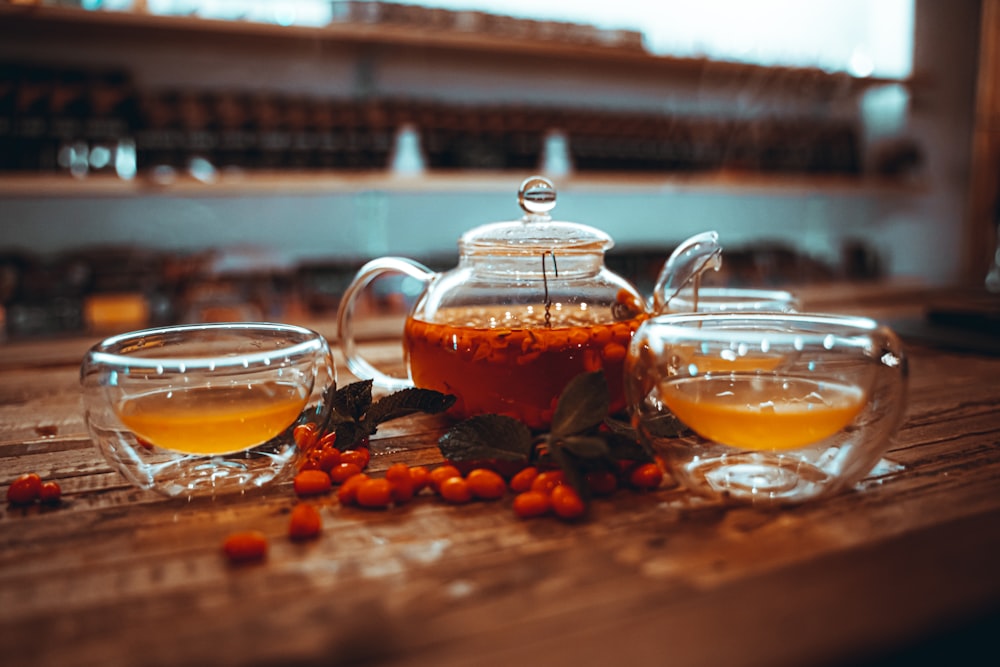 clear glass teapot with orange liquid